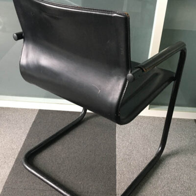 Fauteuil cantilever de marque MATTEO GRASSI modèle MG5, structure en acier chromé, dossier, assise et accoudoirs en cuir noir. (usures).  78 x 57 x 59 cm