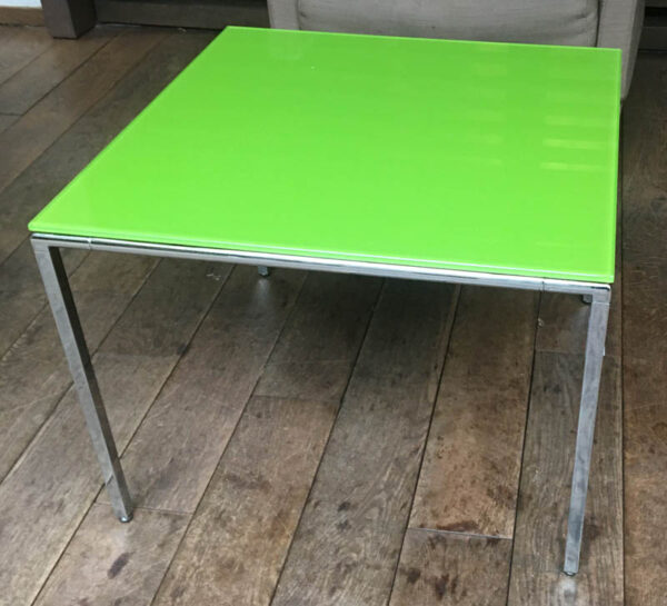Table basse carrée, plateau en verre teinté vert pomme, cadre et piètement en acier chromé. (usures). 45 x 60 x 60 cm.