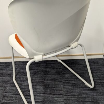 Chaise empilable de marque STEELCASE modèle Westside, coque en plastique blanc avec galette d’assise en tissu orange, piètement luge en acier laqué blanc. 81 x 54 x 59 cm. 40 unités. Vendu à l’unité avec faculté de réunion. Localisation : 6ème, 5ème, 3ème