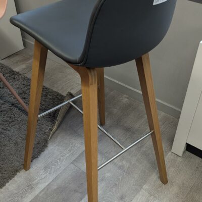 Chaise haute design Thomas Pedersen modèle Deli édition SKANDIFORM, coque en simili cuir gris anthracite reposant sur 4 pieds en bois avec repose-pied en métal. 96 x 40 x 45 cm. Localisation : 3ème