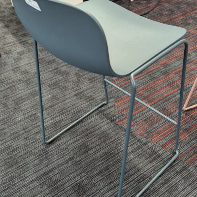 Tabouret haut empilable design Fredrik Mattson modèle Neo Lite édition MATERIA, coque en plastique bleu pétrole reposant sur un piètement luge en acier laqué avec repose-pied. 84 x 44 x 44 cm. Localisation : 3ème