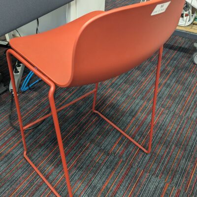 Tabouret haut empilable design Fredrik Mattson modèle Neo Lite édition MATERIA, coque en plastique rouge reposant sur un piètement luge en acier laqué avec repose-pied. 84 x 44 x 44 cm. Localisation : 3ème