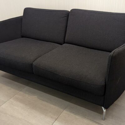 Canapé design Anders Norgaard modèle Osaka édition BO CONCEPT recouvert de tissu noir, coussins amovibles, piètement en métal chromé. 80 x 154 x 86 cm. Localisation : Rdc