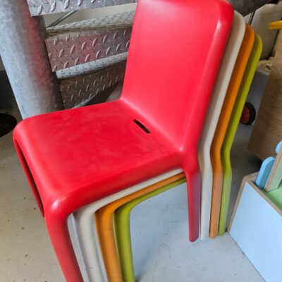 4 Chaises empilables de marque Pédrali design Odoardo Fioravant modèle Snow en plastique de couleur rouge, vert pomme, orange et blanc.