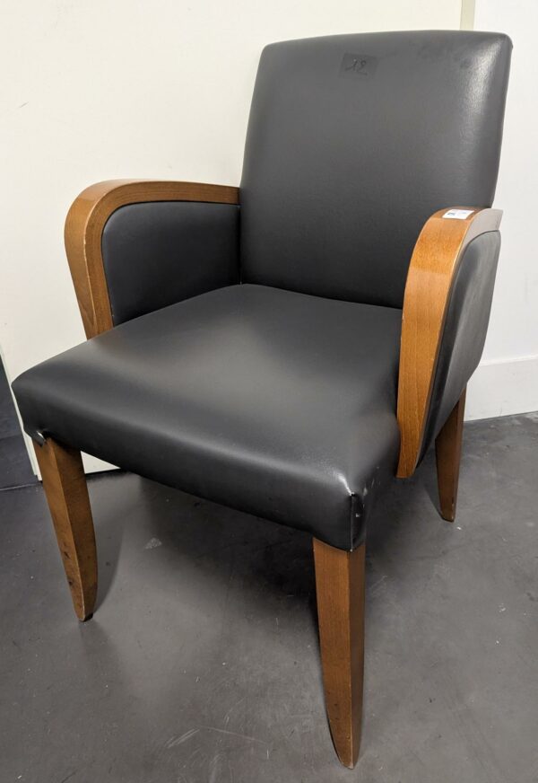 Fauteuils en simili cuir gris anthracite, accoudoirs en bois type chêne clair. 84 x 57 x 60 cm. 16 unités vendues avec faculté de réunion.