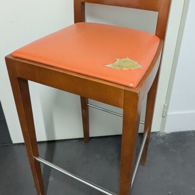 4 chaises hautes en bois stratifié couleur chêne, assise en simili cuir dont 3 vertes et 1 orange (accident). On y joint 2 tabourets hauts coordonnés.