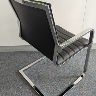 Suite de 3 fauteuils de marque QUADRIFOGLIO, structure en acier chromé, garniture en cuir noir, piètement en porte à faux. 87 x 56 x 56 cm. Localisation : 7 ouest