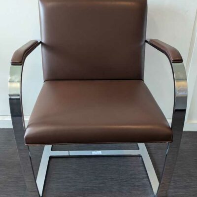 Fauteuil design Mies Von der Rohe modèle Brno édition KNOLL, structure en acier chromé, garniture en cuir marron. 80 x 58 x 55 cm. Localisation : 7 est