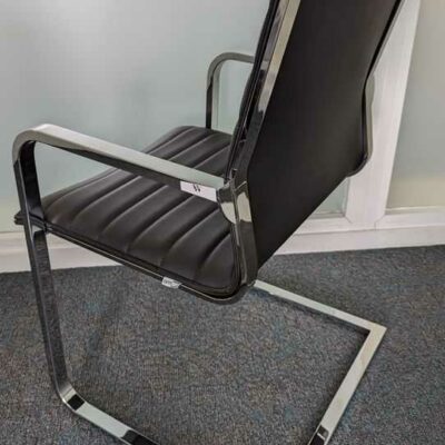 Suite de 4 fauteuils de marque OFFICIT, structure en acier chromé, garniture en cuir noir, piètement en porte à faux. 87 x 56 x 56 cm. Localisation : 7 ouest