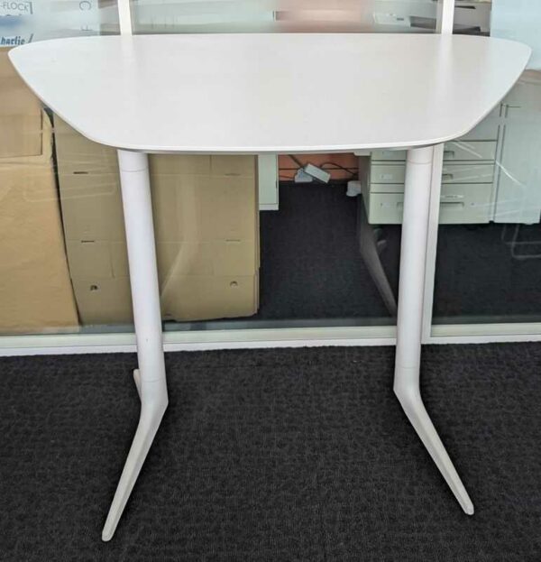 Table haute de marque EFE en bois stratifié blanc à plateau trapézoïdal reposant sur 2 pieds en acier laqué blanc. 71 x 140 x 110 cm. Localisation : 7 ouest