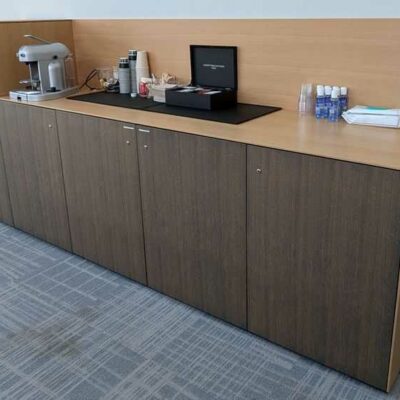 Buffet bas avec compartiment réfrigérateur intégrable en bois stratifié couleur chêne clair et chêne foncé ouvrant par 5 portes.  130 x 302 x 60 cm. Localisation : 7 ouest