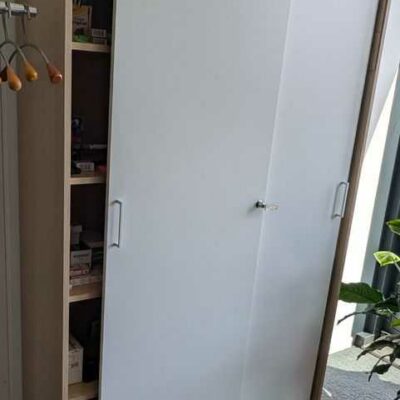 Armoire de marque NARBUTAS en bois couleur chêne clair ouvrant par 2 portes coulissantes en bois laqué blanc sur 4 étagères. 192 x 120 x 40 cm. Localisation : 7 est