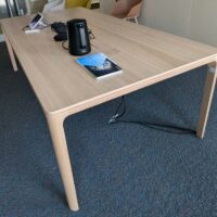 Table de réunion en bois couleur chêne clair, plateau rectangulaire à bords arrondis avec 2 trappes passe-câbles. 76 x 240 x 120 cm. Localisation : 6 ouest – Image 4