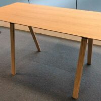 Table haute en bois couleur chêne clair plateau rectangulaire reposant sur 4 pieds obliques. 104 x 200 x 90 cm. Localisation : 6 passerelle – Image 2