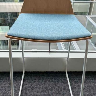 3 chaises hautes de marque COALESSE, coque en bois, galette d’assise en tissu bleu, piètement en acier laqué blanc. 91 x 46 x 52 cm. Localisation : 5 ouest