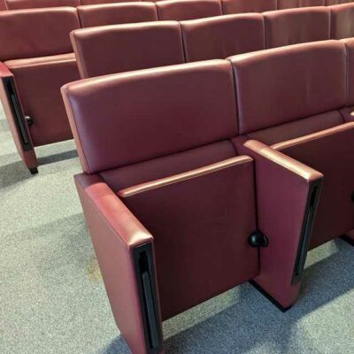 Rang de fauteuils de salle d’auditorium composé de 8 sièges en cuir bordeaux de marque POLTRONA FRAU avec tablette rétractable. 90 x 488 x 70 cm. Localisation : 7 est