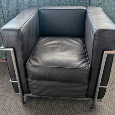 Fauteuil dans le goût du modèle LC2 de Le Corbusier en cuir marron, cadre en acier chromé. 67 x 76 x 70 cm. Localisation : Canada entrée