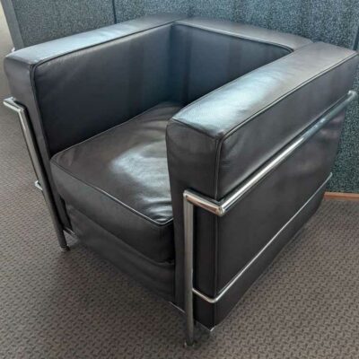 Fauteuil dans le goût du modèle LC2 de Le Corbusier en cuir marron, cadre en acier chromé. 67 x 76 x 70 cm. Localisation : Canada hall