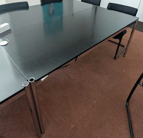 Table de marque USM HALLER modèle T69, plateau rectangulaire en bois de couleur noire reposant sur une structure en acier chromé. 74 x 175 x 75 cm. (usures). 9 unités. Vendu avec faculté de réunion. Localisation : Canada 1er (2b17, 2b19, 2b20, 2b21)
