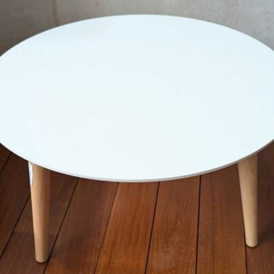 Table basse en bois, plateau blanc reposant sur 4 pieds obliques en bois naturel. 38 x 60 cm. Localisation : Canada hall