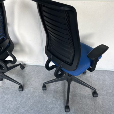 Fauteuil sur roulettes, assise en tissu bleu, dossier en résine noir