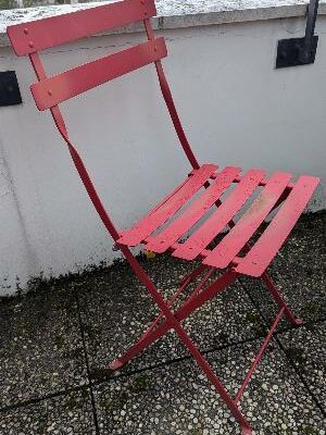 Mobilier de jardin pliable de marque FERMOB modèle Bistro comprenant une table ronde (72 x 60 cm) et 4 chaises en métal rouge (80 x 40 x 40 cm). Localisation : 10 rue du Ballon 93160 Noisy le Grand