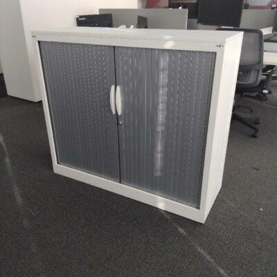 Armoire métallique mi haute de marque Magencia, structure en métal blanc porte coulissante grise.. Dimensions:  100 par 120 par 45 cm. 16 unités vendues avec faculté de réunion. Localisation : Tour Coeur Défense A 100 esplanade Du Général de Gaulle 92400 Courbevoie