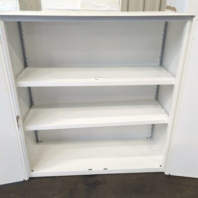Armoire métallique mi-haute en acier laqué blanc ouvrant par deux portes battantes. 105 x 100 x 46 cm. 17 unités vendues avec faculté de réunion. Localisation : 8 rue de la Fossé aux Leux 91700 Ste Geneviève des Bois