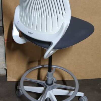 Chaise haute pivotante ajustable de marque Steelcase modèle Cobi, arrière du dossier en plastique blanc, dossier en résille grise, assise en tissu gris, piétement en étoile à 5 branches sur roulettes avec repose-pied. 120 x 48 x 68 cm. Localisation : 8 rue de la Fossé aux Leux 91700 Ste Geneviève des Bois