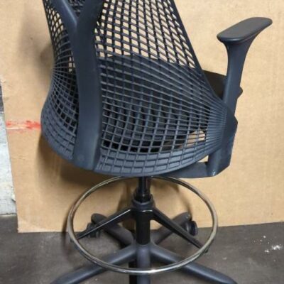 Fauteuil haut pivotant ajustable de marque Herman Miller modèle Sayl, armature en plastique noir, assise en tissu noir, piètement en étoile à 5 branches sur roulettes avec repose-pied. (manque 1 roulette). 125 x 60 x 65 cm. Localisation : 8 rue de la Fossé aux Leux 91700 Ste Geneviève des Bois