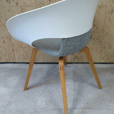 Fauteuil design Thomas Pedersen modèle Deli édition Skandiform, coque en plastique ajouré blanc, galette en tissu chiné gris clair, piétement en bois naturel. 80 x 62 x 55 cm. 2 unités vendues avec faculté de réunion. Localisation : 9 avenue Percier 75008 Paris