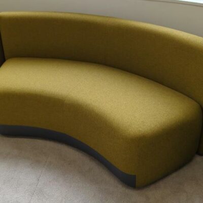2 banquettes en arc de cercle de marque Viccarbe recouvertes de tissu chiné jaune et gris. 75 x 170 x 73 cm. Localisation : 9 avenue Percier 75008 Paris