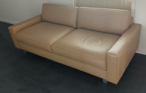Canapé 2 places recouvert de cuir beige, piètement en métal. 75 x 200 x 90 cm. (Belgrand 6e). 2 unités. Vendu à l'unité avec faculté de réunion