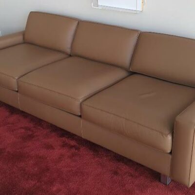 Canapé trois places recouvert de cuir marron glacé coussins et dossiers amovibles, pieds en acier chromé. 70 x 230 x 92 cm (Belgrand 6e)