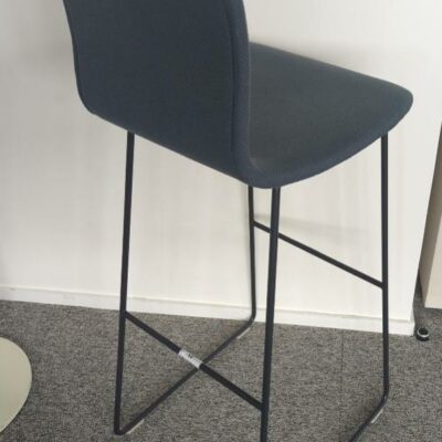 Chaise haute de marque Capellini recouverte de tissu bleu gris, piètement en acier laqué anthracite. 112 x 40 x 47 cm. (Belgrand 8e). 3 unités. Vendu à l’unité avec faculté de réunion