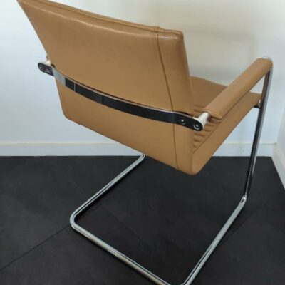 Fauteuil de marque Comforto recouvert de cuir marron, piètement en porte-à-faux en acier chromé. 85 x 57 x 50 cm. (Belgrand 6e). 6 unités. Vendu à l’unité avec faculté de réunion