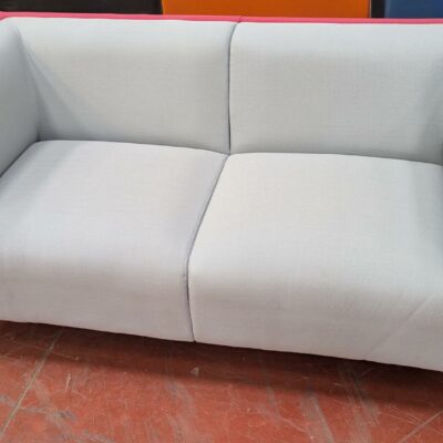 Canapé de marque Connection recouvert de tissu bicolore bleu clair et fuschia, 4 pieds en acier chromé. 76 x 162 x 77 cm.  Localisation : 8 rue de la Fossé aux Leux 91700 Ste Geneviève des Bois