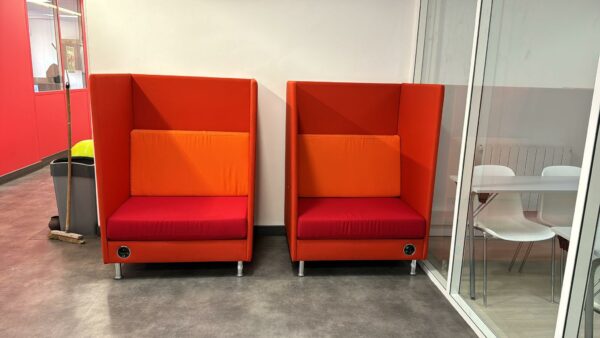 Fauteuil acoustique connecté de marque Dauphin modèle Atelier, parois en tissu rouge orangé, coussin de dossier amovible orange et coussin d'assise rouge, 4 pieds réglables chromés. Bloc prises en façade basse (à gauche ou à droite) comprenant une prise courant, une prise USB et une prise RJ45. 138 x 96 x 80 cm. 2 unités, vendues à l'unité avec possibilité de réunion. Localisation : 54 Avenue Philippe Auguste 75011 Paris