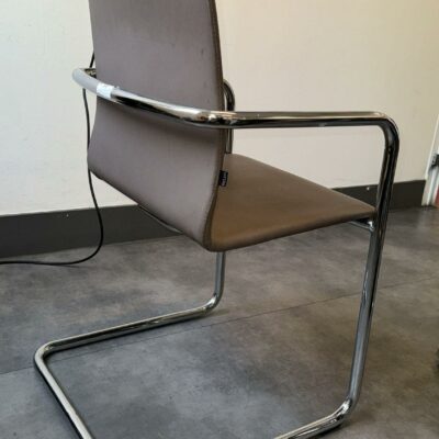 Fauteuil visiteur de marque Inclass, dossier et assise en cuir gris anthracite reposant sur un piétement en porte à faux en acier chromé. 85 x 53 x 56 cm. Localisation : 54 Avenue Philippe Auguste 75011 Paris