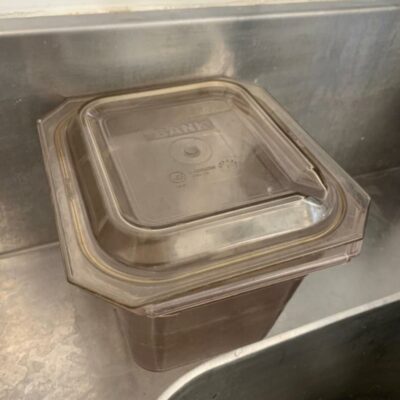 Lot de bacs gastronomes en plastique teinté transparents et emboîtables. Ensemble comprenant plusieurs bacs de tailles variées, accompagnés de leurs couvercles.