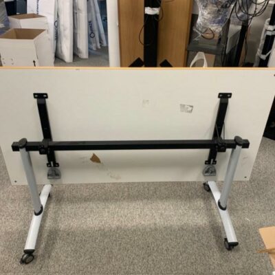 Table mobile à plateau basculant – 160 x 80 x H74 cm. Plateau en mélaminé finition hêtre, structure métal avec 4 roulettes à frein. Piètement emboîtable pour gain de place. 5 unités. Vendu à l’unité avec faculté de réunion.