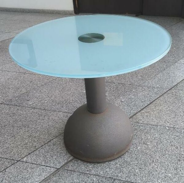 Table d'appoint, plateau rond en verre fumé vert reposant sur un pied conique en fonte d'acier. 60 x 70 cm. 3 unités. Vendu à l'unité avec faculté de réunion. Localisation : 8 av. de Lunca - 78180 Montigny-le-Bretonneux. (hall, bureau expat)