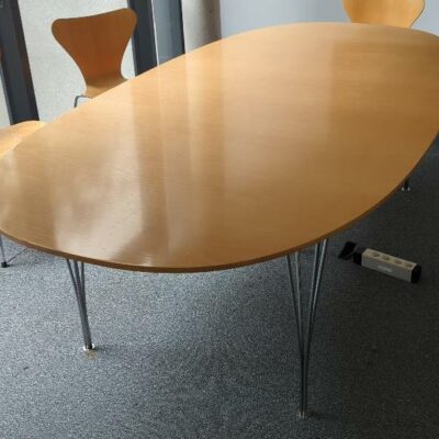 Table ovale design Arne Jacobsen, Piet Hein et Bruno Mathsson modèle Super Elliptique édition Fritz Hansen, plateau en bois couleur noyer, piètement en tiges d’acier chromé. 70 x 240 x 120 cm. 1er