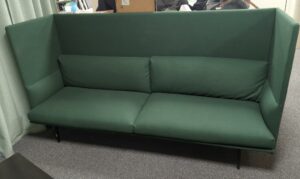 Canapé 4 places à haut dossier de marque Muuto recouvert de feutrine vert foncé, coussins amovibles et déhoussables, pieds en acier laqué noir. 116 x 220 x 75 cm. rdc