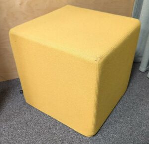 Pouf carré de marque Buzzy Space recouvert de tissu jaune. 47 x 47 x 47 cm. rdc