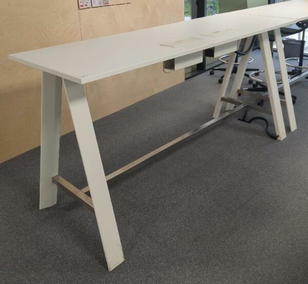 Table haute rectangulaire avec deux trappes passe câbles, plateau en bois, piètement en acier laqué blanc. 105 x 210 x 70 cm. 3 unités. Vendu à l'unité avec faculté de réunion. rdc