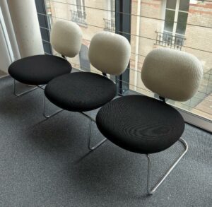 Espace d'attente design Jasper Morrison modèle Vega comprenant 3 sièges solidarisés recouverts de tissu noir et blanc, structure en acier chromé. 75 x 168 x 58 cm. 2eme