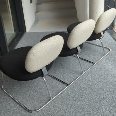 Espace d’attente design Jasper Morrison modèle Vega comprenant 3 sièges solidarisés recouverts de tissu noir et blanc, structure en acier chromé. 75 x 168 x 58 cm. 2eme