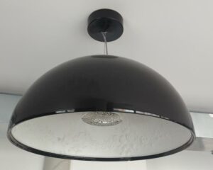 Suspension lumineuse design Marcel Wanders modèle Skygarden édition Flos, coupole en plâtre coulé, extérieur noir brillant, intérieur blanc orné d'arabesques florales en relief. 60 x 56 cm. (accident au socle). 3eme. 2 unités. Vendu à l'unité avec faculté de réunion.