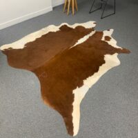 Tapis en peau de vache naturelle, teintes brunes et blanches. 
200 x 100 cm.
Localisation : Rdc – Image 2